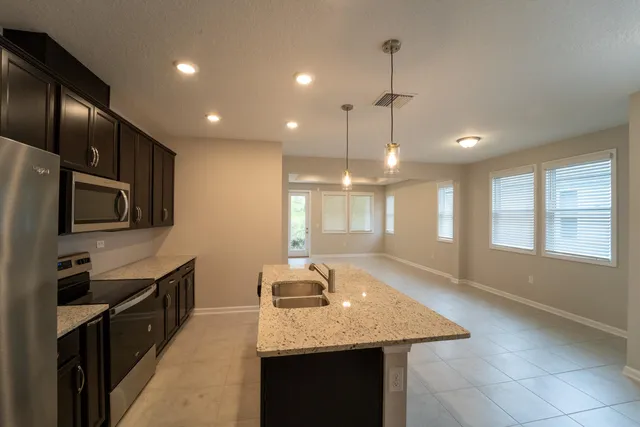 a kitchen with stainless steel appliances granite countertop a sink a stove and a refrigerator