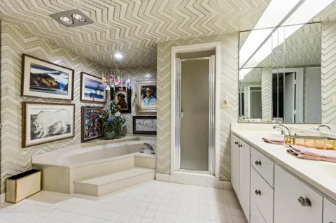 a spacious bathroom with a tub sink and mirror