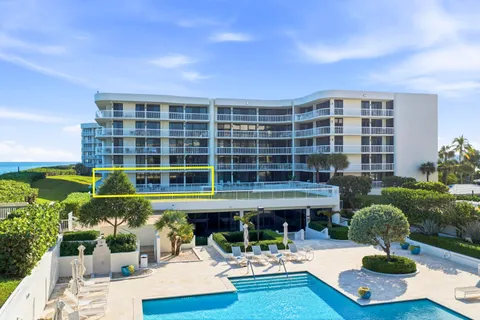 a front view of a building with swimming pool and table and chairs