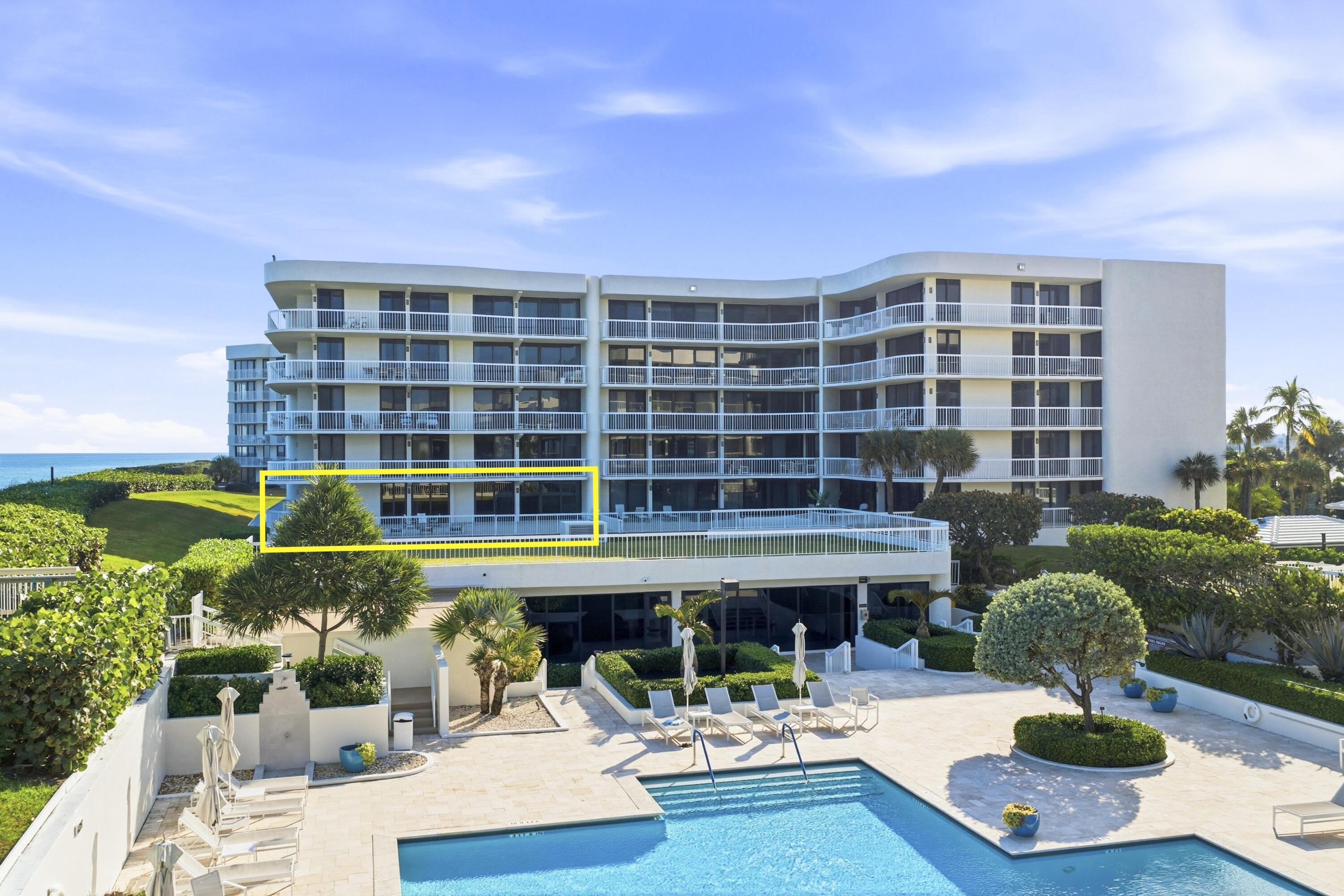 3300 South Ocean Boulevard, Unit 103S Palm Beach, FL 33480 - Photo 3 of 20 a front view of a building with swimming pool and table and chairs