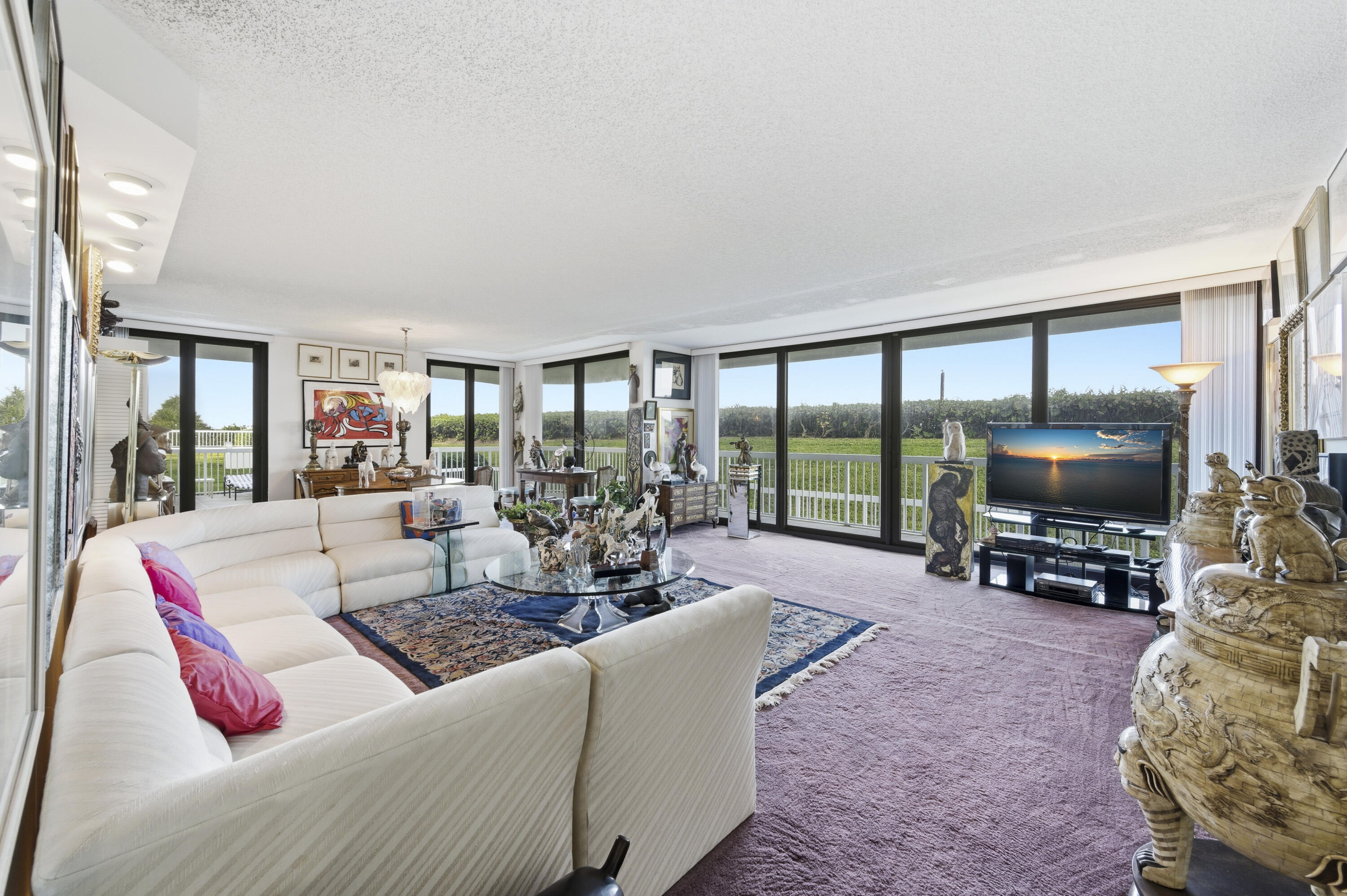 3300 South Ocean Boulevard, Unit 103S Palm Beach, FL 33480 - Photo 6 of 20 a living room with furniture a flat screen tv and floor to ceiling window