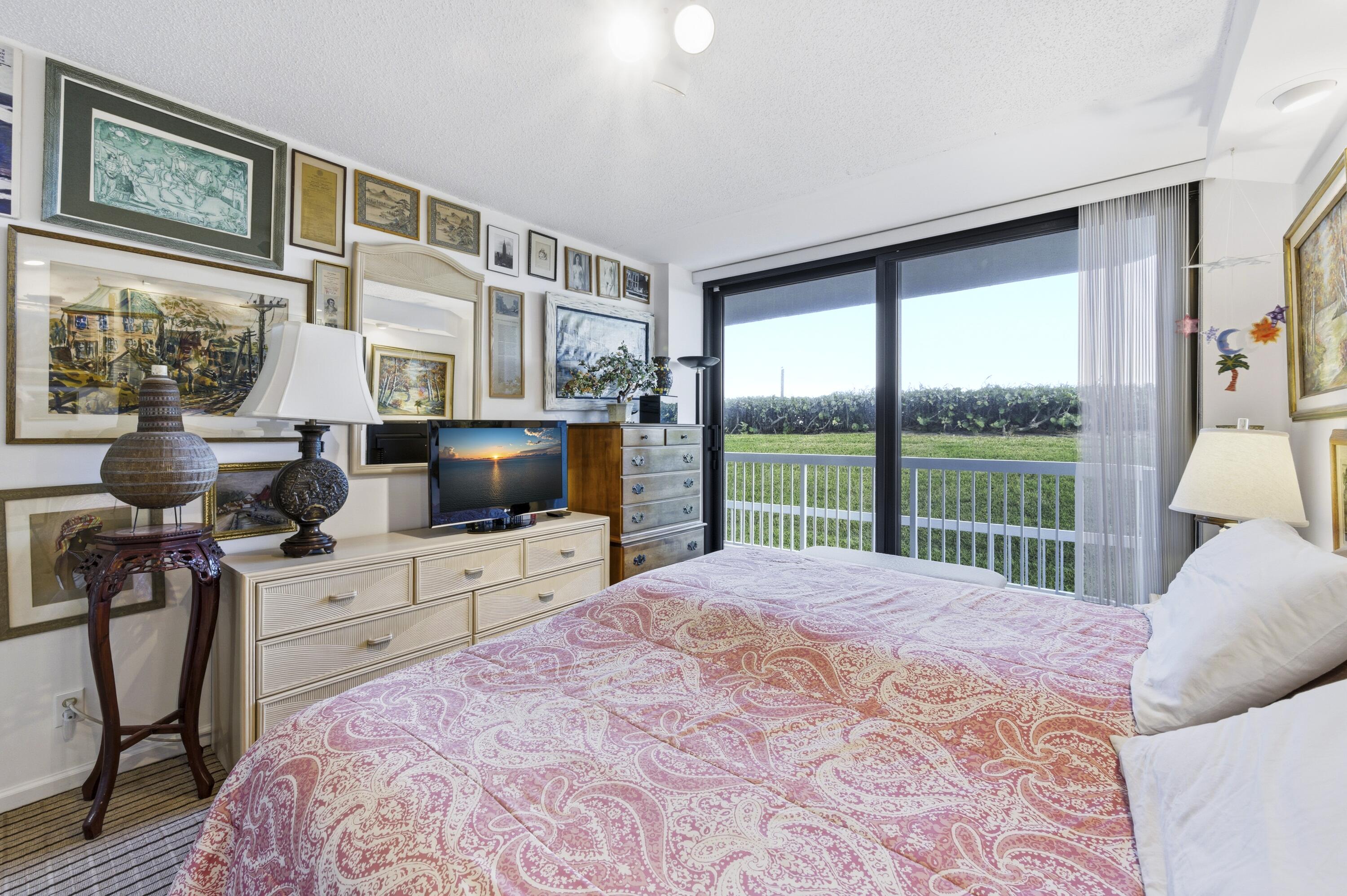 3300 South Ocean Boulevard, Unit 103S Palm Beach, FL 33480 - Photo 9 of 20 a bedroom with a bed and glass door