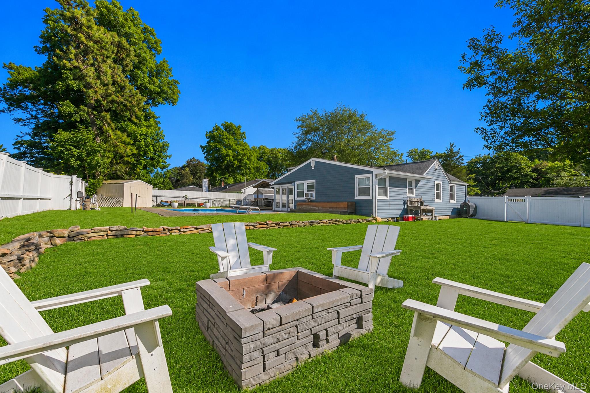 33 Lillian Road Nesconset, NY 11767 - Photo 33 of 42 The Large Fully PVC Fenced Backyard Also Has Beautiful Stone/Rock Walls, Expansive Lawns/Beautiful Grasses With Ample Room For Entertaining, And A Firepit Area.