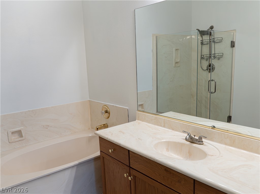 1466 Orange Jubilee Road Henderson, NV 89014 - Photo 10 of 15 A well-appointed bathroom features a single vanity with an integrated sink and a spacious bathtub, reflecting classic comfort.