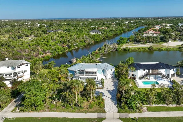 an aerial view of residential houses with outdoor space and lake view