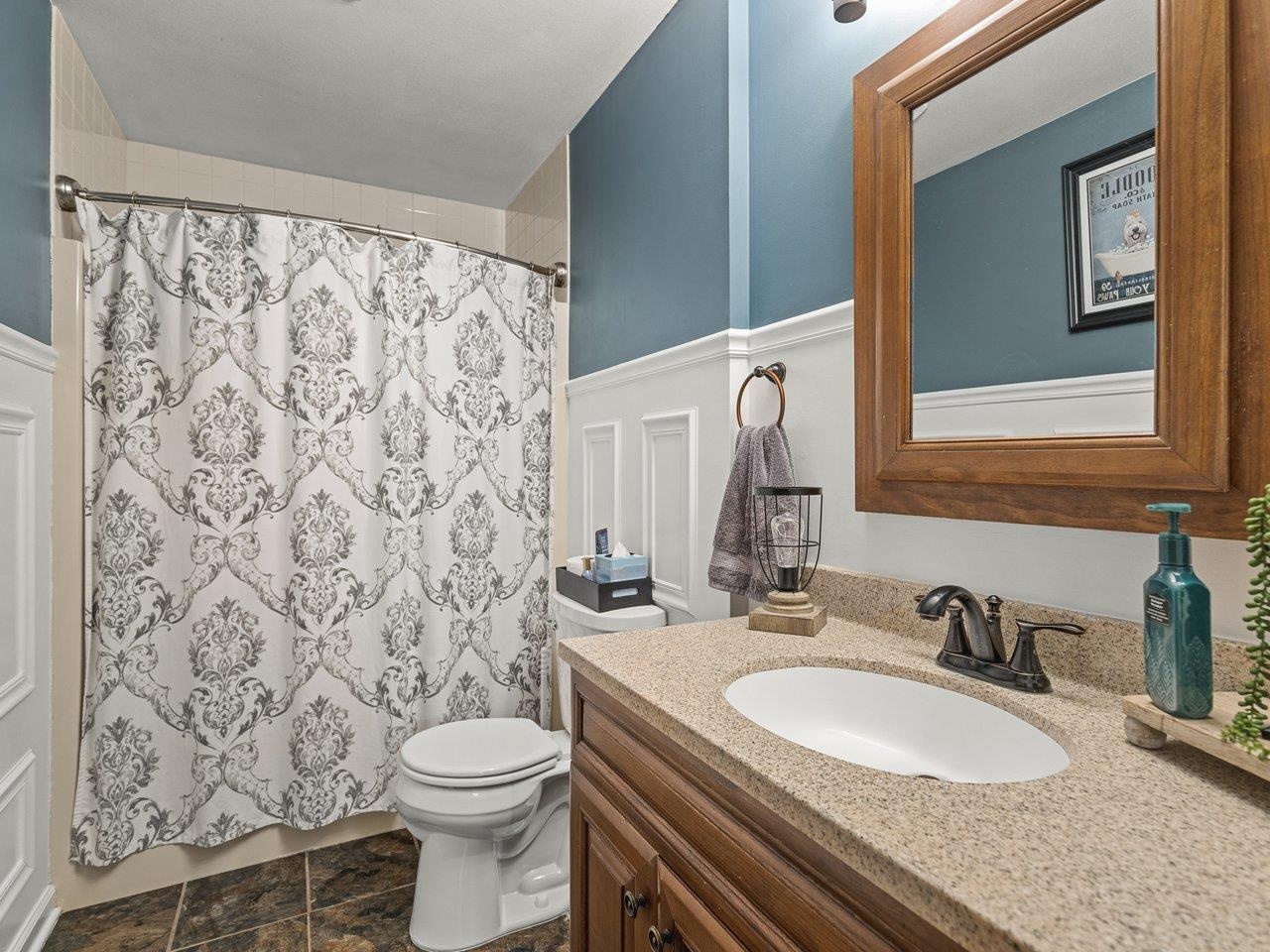 1816 Post Road Beloit, WI 53511 - Photo 17 of 42 a bathroom with a granite countertop sink a toilet and a mirror