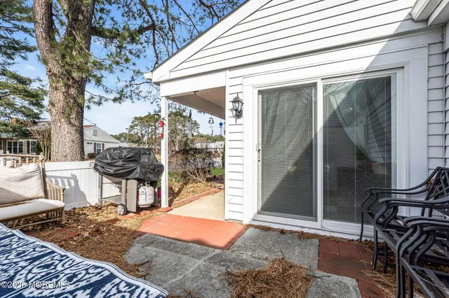 a patio with glass top table and chairs
