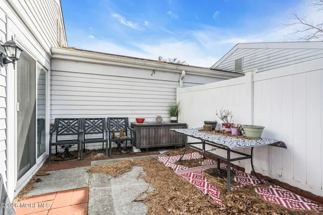 a view of a white house next to a yard and large trees