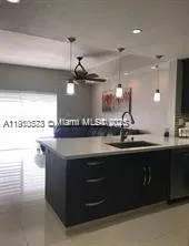 a kitchen with stainless steel appliances kitchen island granite countertop a refrigerator and a stove