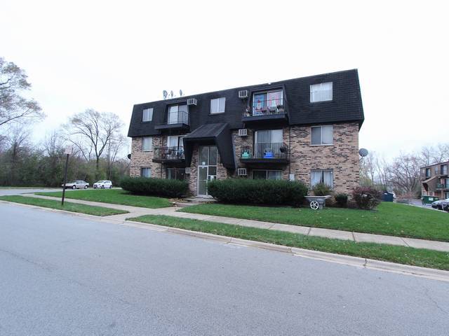 4839 West Engle Road, Unit 2D Alsip, IL 60803 - Photo 15 of 16 a brick house with a small yard and large trees