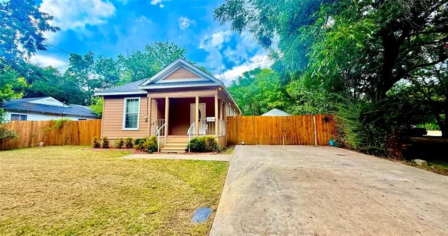 a view of house with backyard and tree