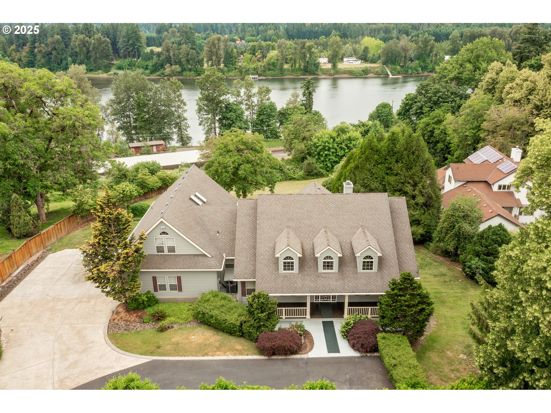 an aerial view of a house with garden space and lake view