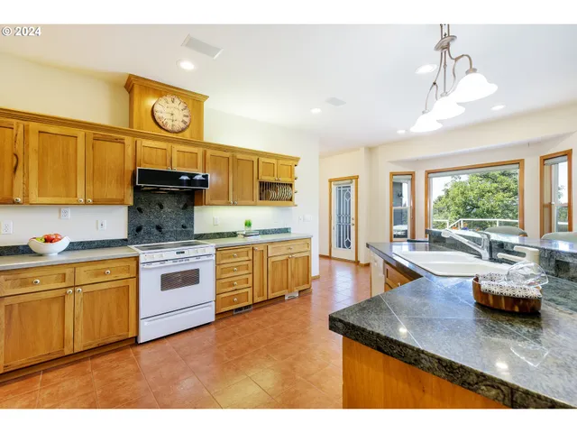a kitchen with kitchen island granite countertop a sink counter top space and living room area