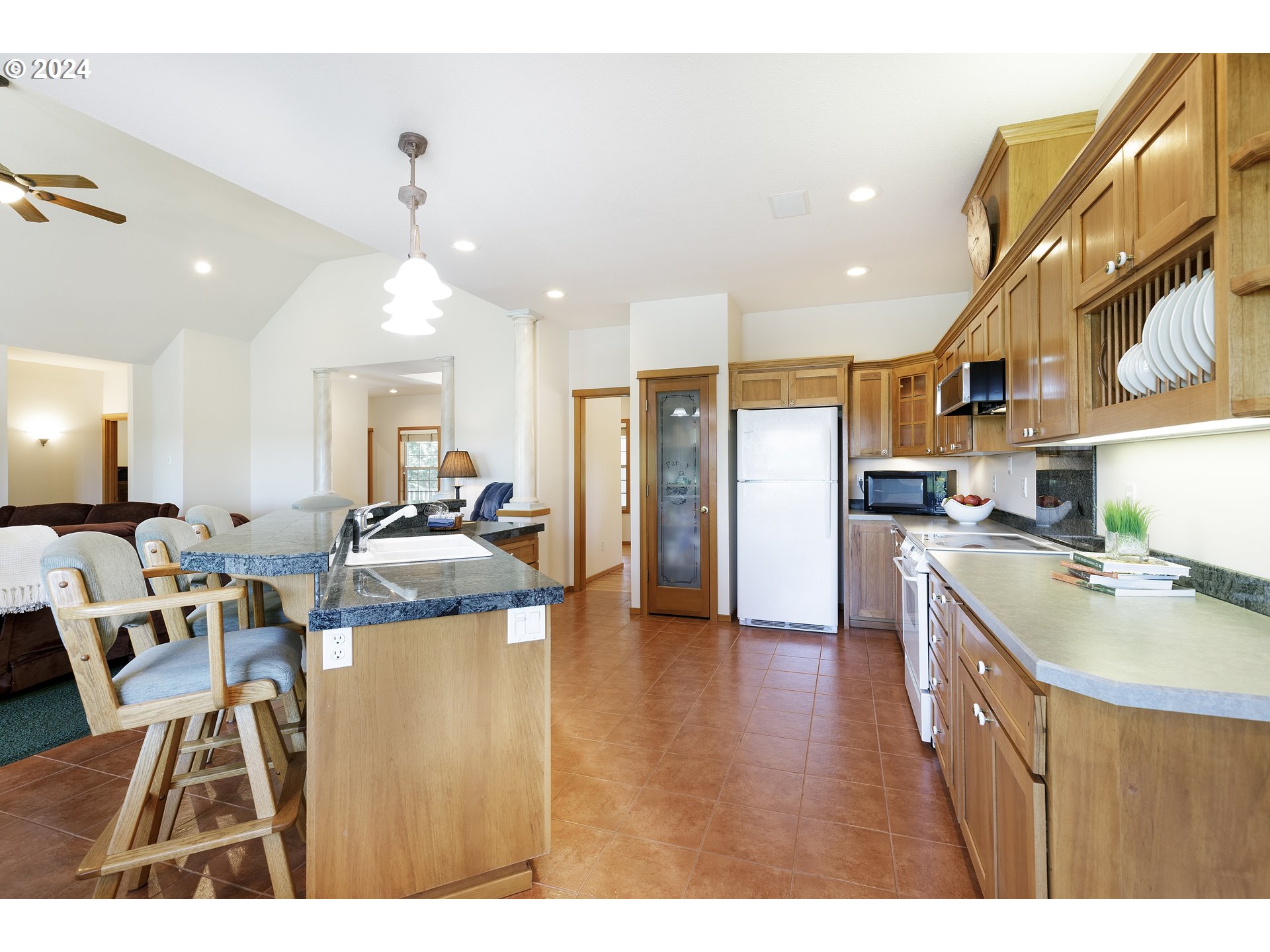 10202 South New Era Road Canby, OR 97013 - Photo 16 of 48 a open kitchen with kitchen island a refrigerator a stove a sink a dining table and chairs with wooden floor