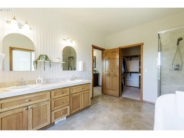 a view of a big room with windows and chandelier fan
