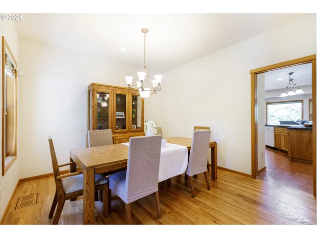 a dining room with furniture a chandelier and wooden floor