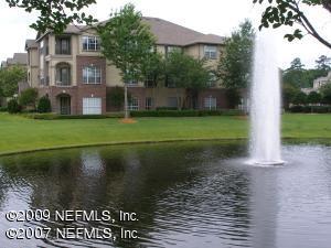 7800 Point Meadows Drive, Unit 422 Jacksonville, FL 32256 - Photo 1 of 1 a view of a brick house next to a yard with big trees