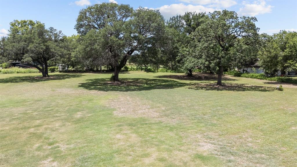 220 South Ash Street Springtown, TX 76082 - Photo 3 of 40 a view of a yard with trees