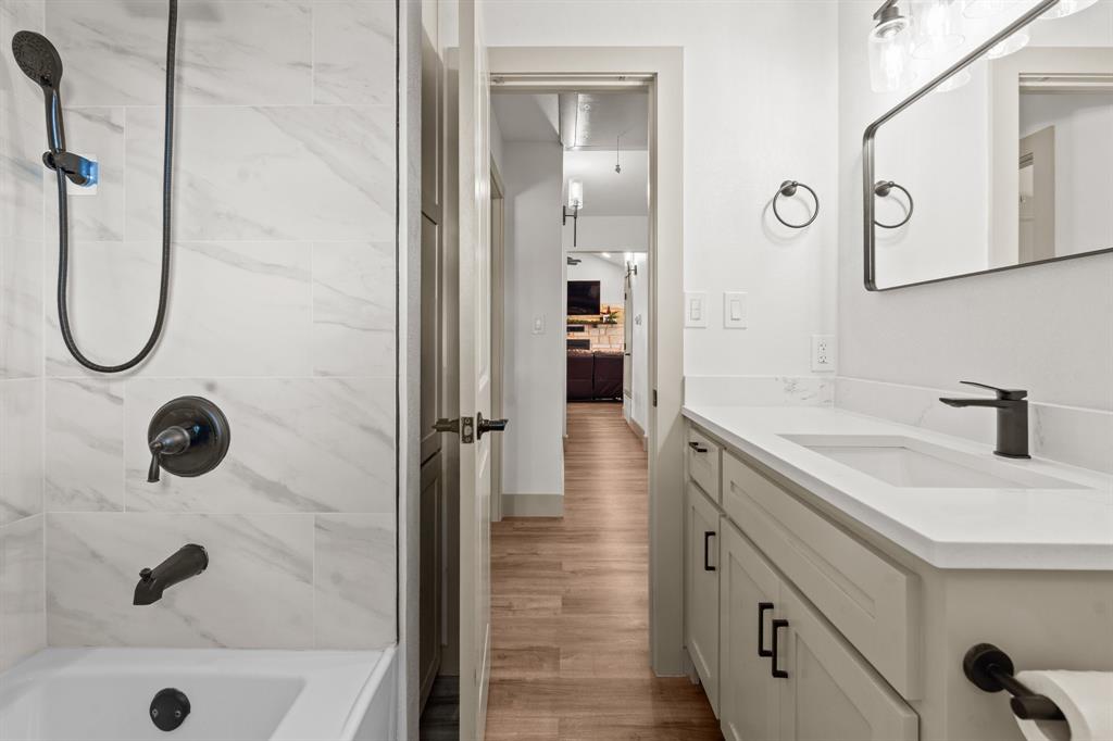 220 South Ash Street Springtown, TX 76082 - Photo 31 of 40 a bathroom with a tub sink a mirror and shower