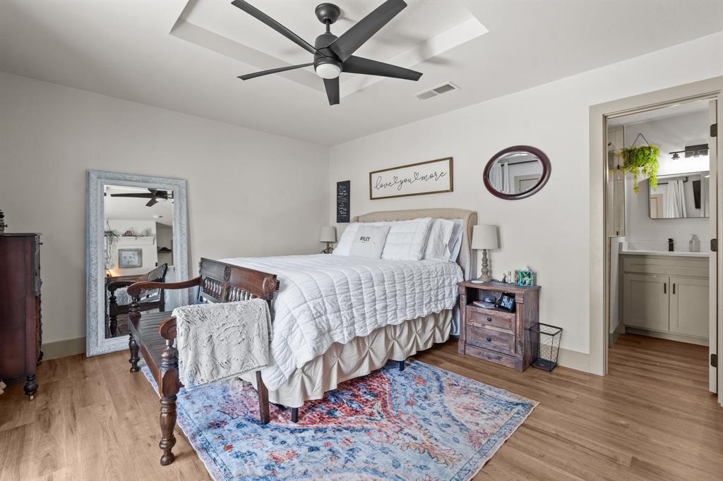 220 South Ash Street Springtown, TX 76082 - Photo 33 of 40 a bedroom with a bed and a chandelier