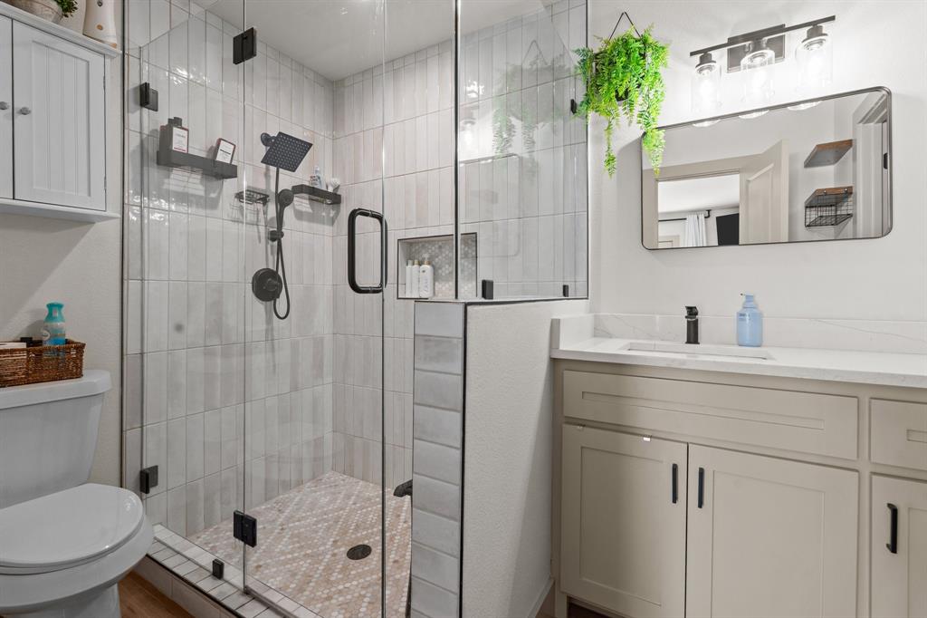 220 South Ash Street Springtown, TX 76082 - Photo 34 of 40 a bathroom with a shower sink vanity mirror and toilet