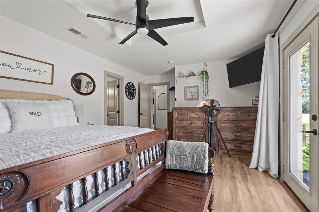 220 South Ash Street Springtown, TX 76082 - Photo 35 of 40 a bedroom with a bed a dresser and flat screen tv