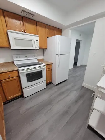 a kitchen with a refrigerator a stove top oven a sink and a window