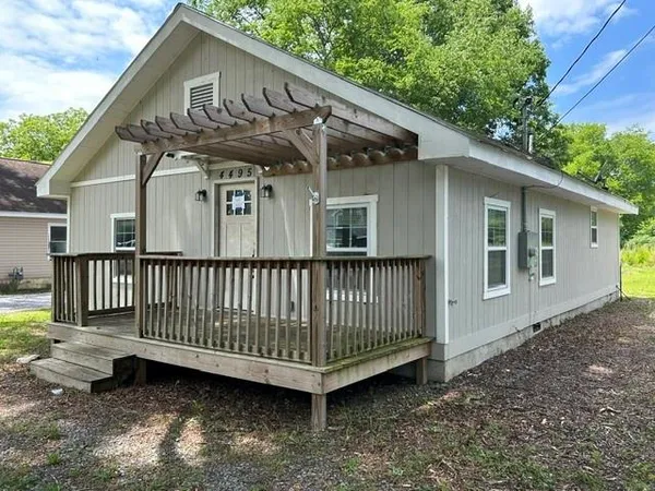 a view of a house with a yard and deck