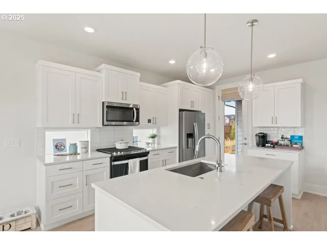 a kitchen with kitchen island a sink stainless steel appliances and cabinets