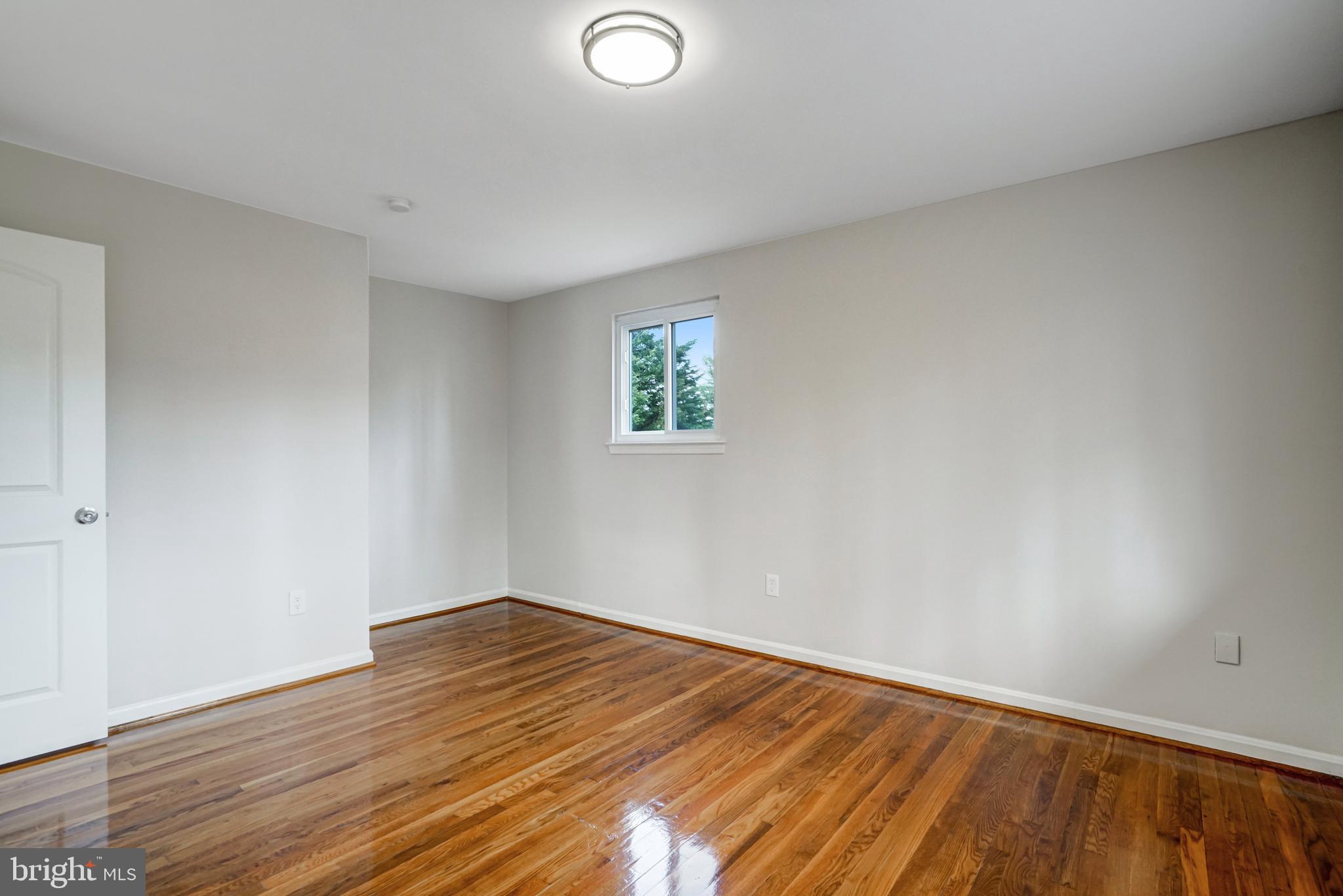 8941 Burke Lake Road Springfield, VA 22151 - Photo 15 of 34 an empty room with wooden floor and windows