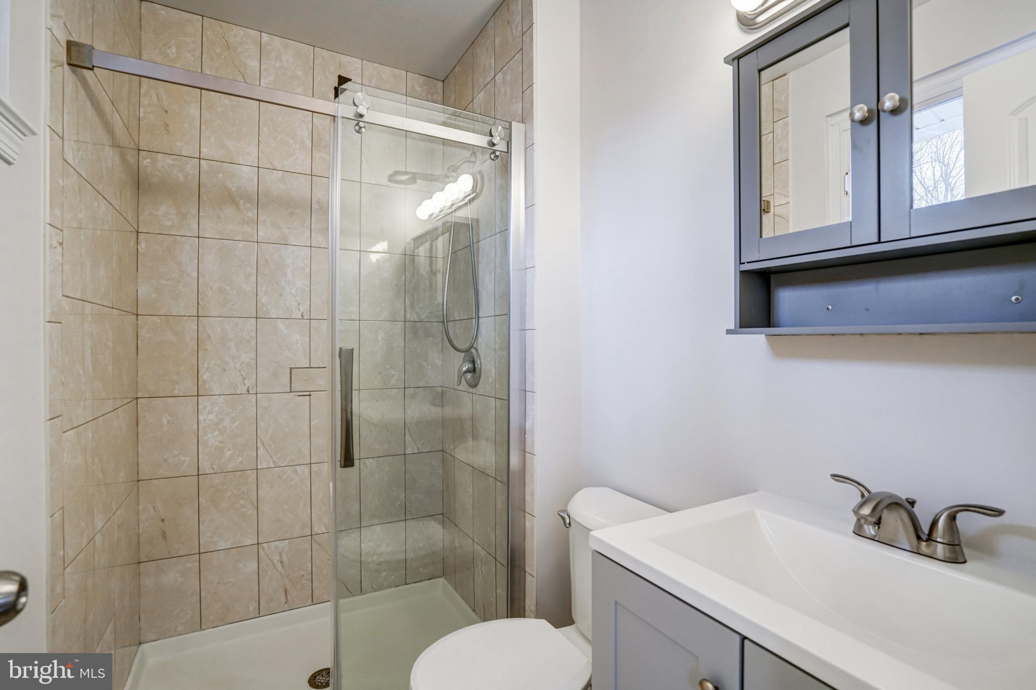 8941 Burke Lake Road Springfield, VA 22151 - Photo 17 of 34 a bathroom with a sink toilet a mirror and shower