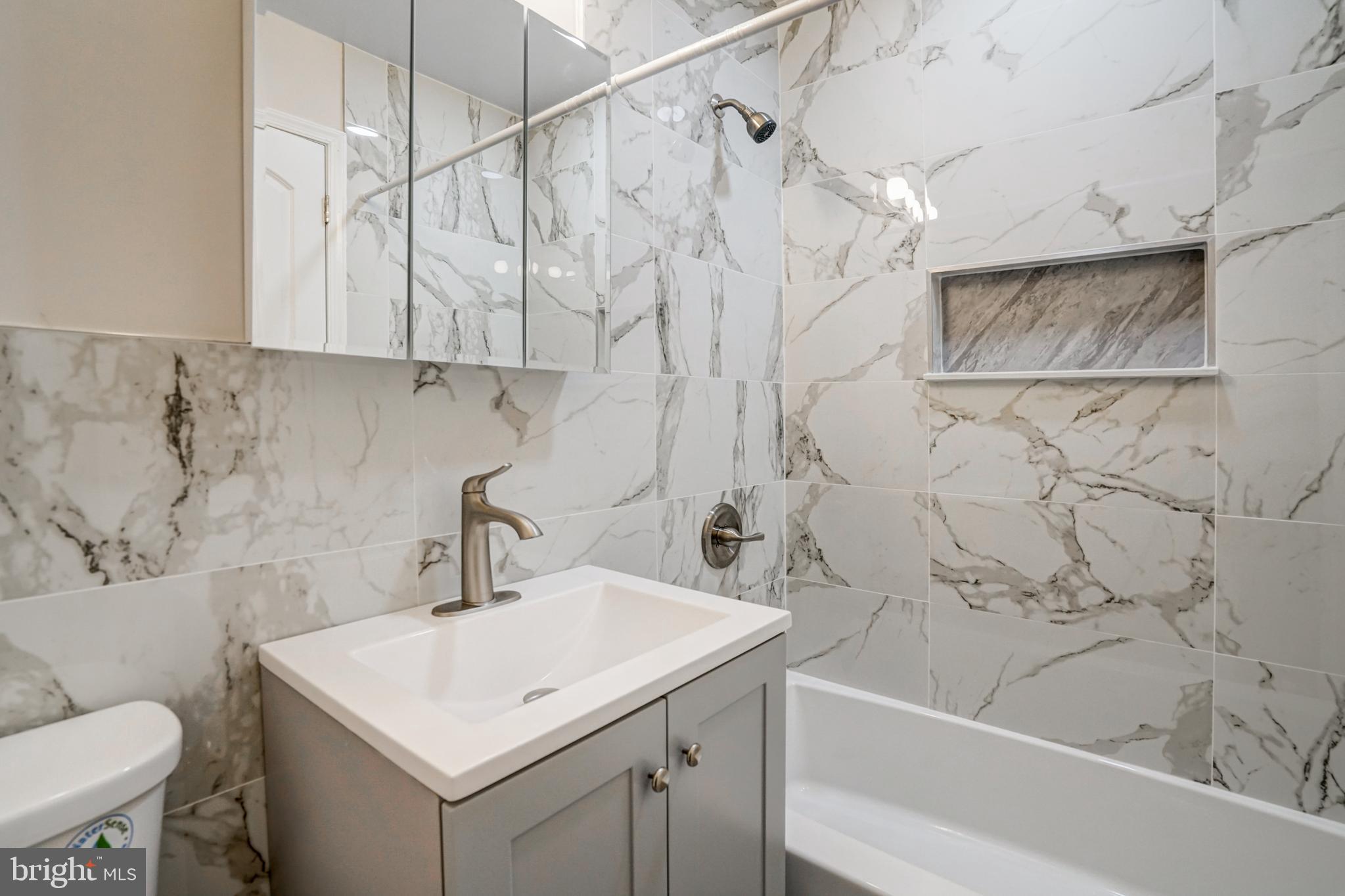 8941 Burke Lake Road Springfield, VA 22151 - Photo 18 of 34 a bathroom with a sink a toilet and a bathtub