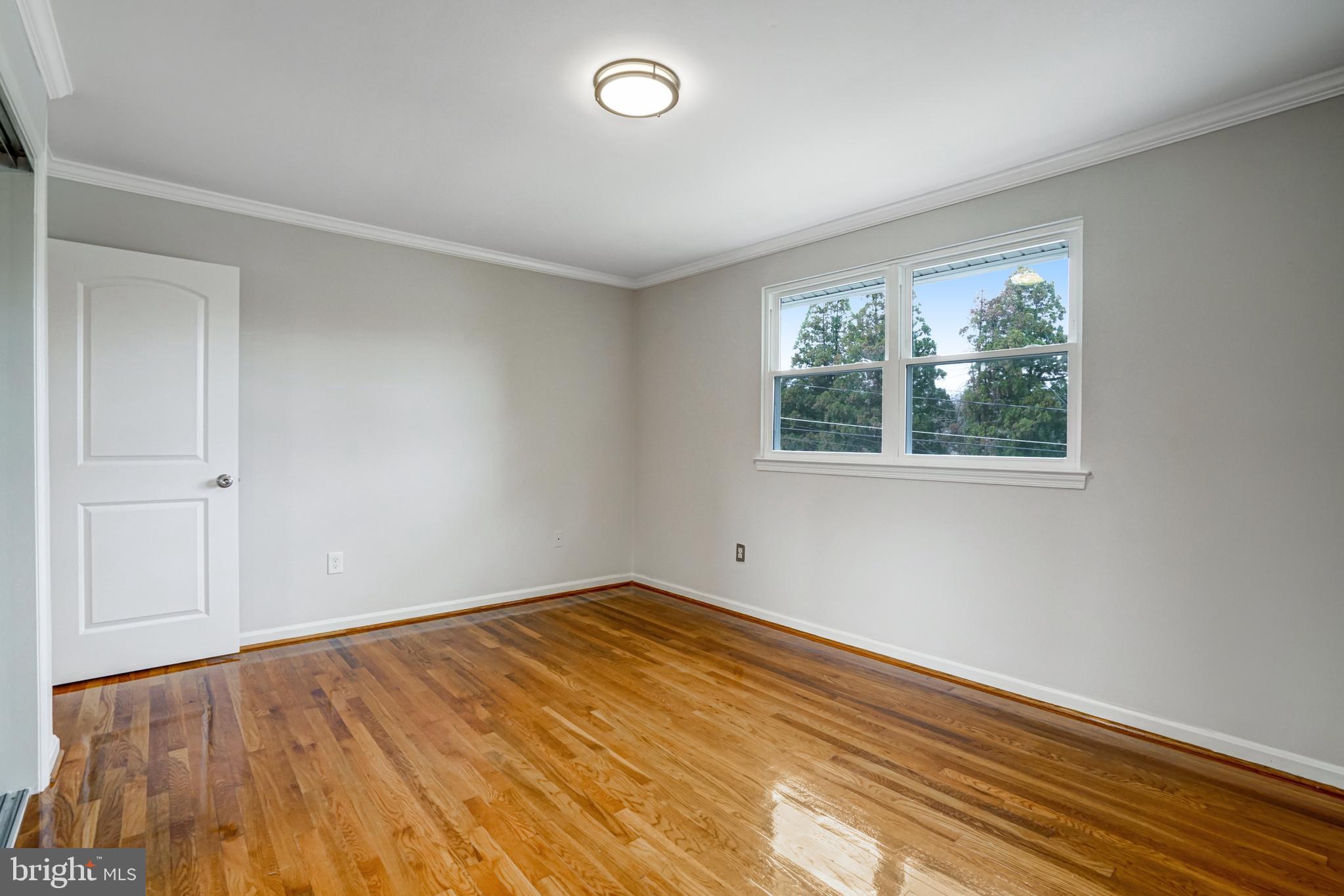 8941 Burke Lake Road Springfield, VA 22151 - Photo 19 of 34 a view of an empty room with wooden floor and a window