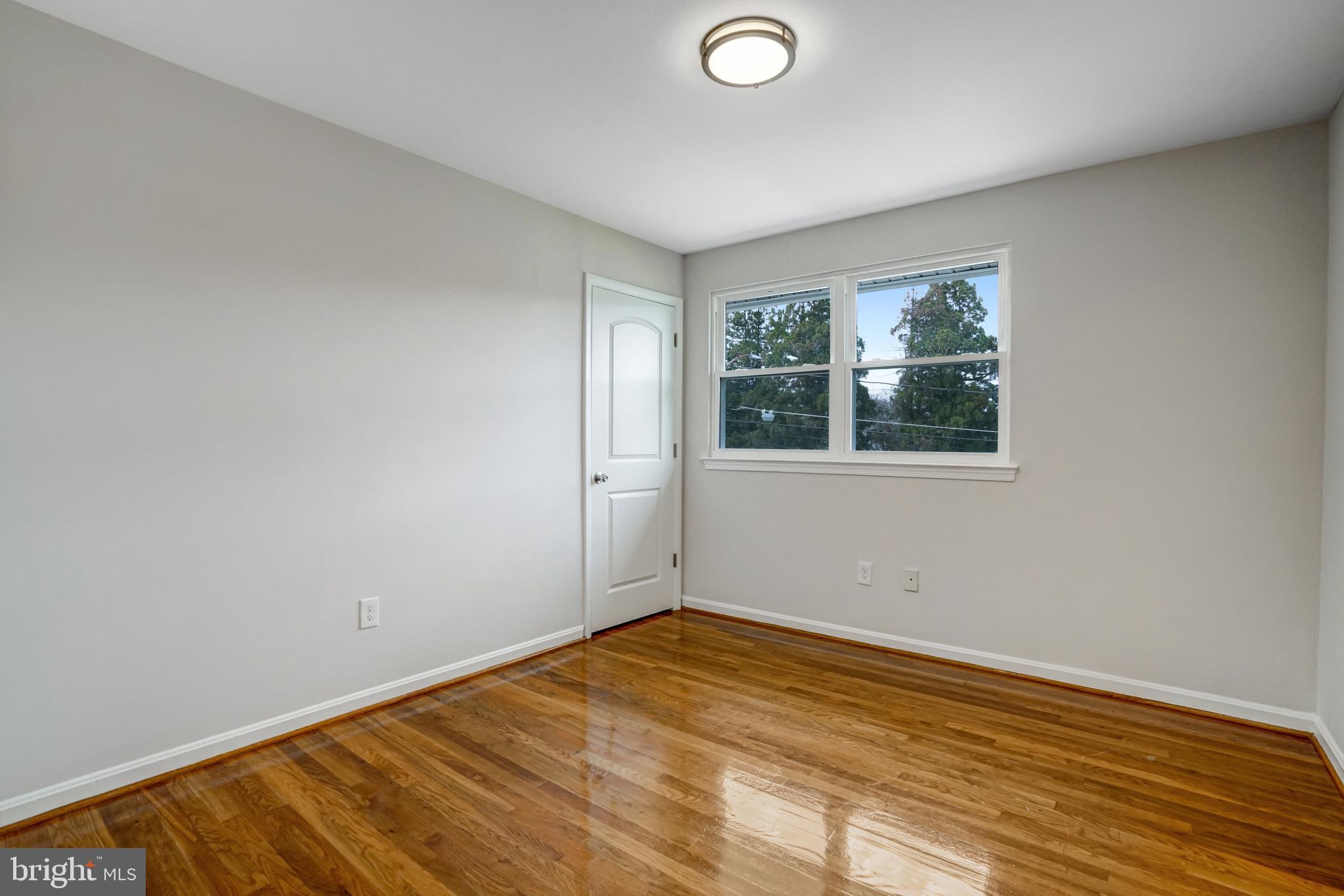 8941 Burke Lake Road Springfield, VA 22151 - Photo 21 of 34 an empty room with wooden floor and windows