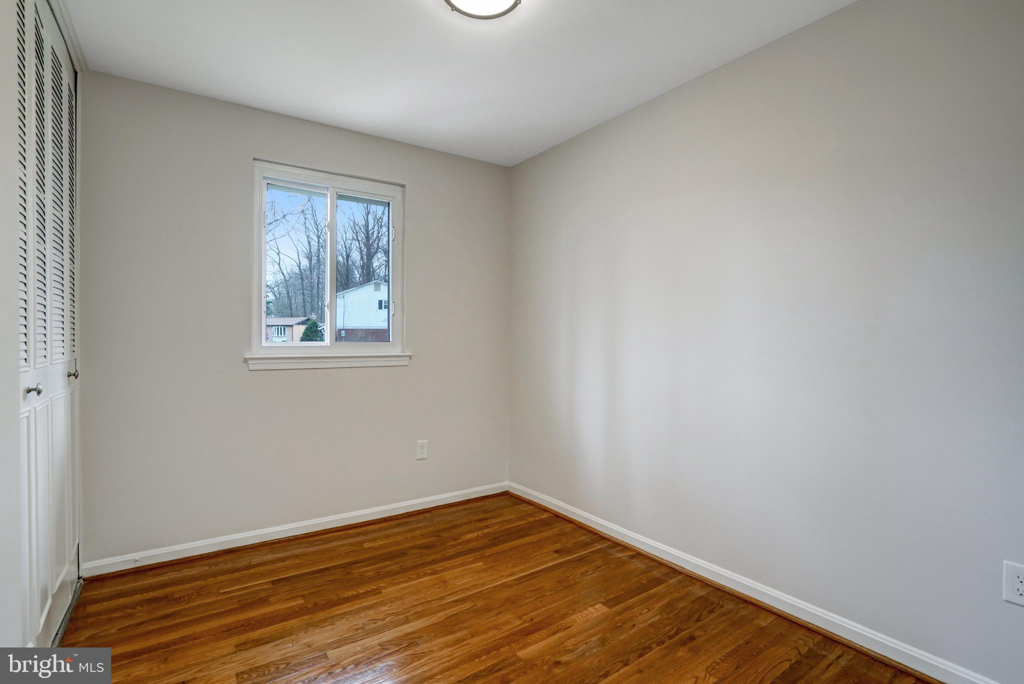 8941 Burke Lake Road Springfield, VA 22151 - Photo 23 of 34 a view of an empty room with wooden floor and a window