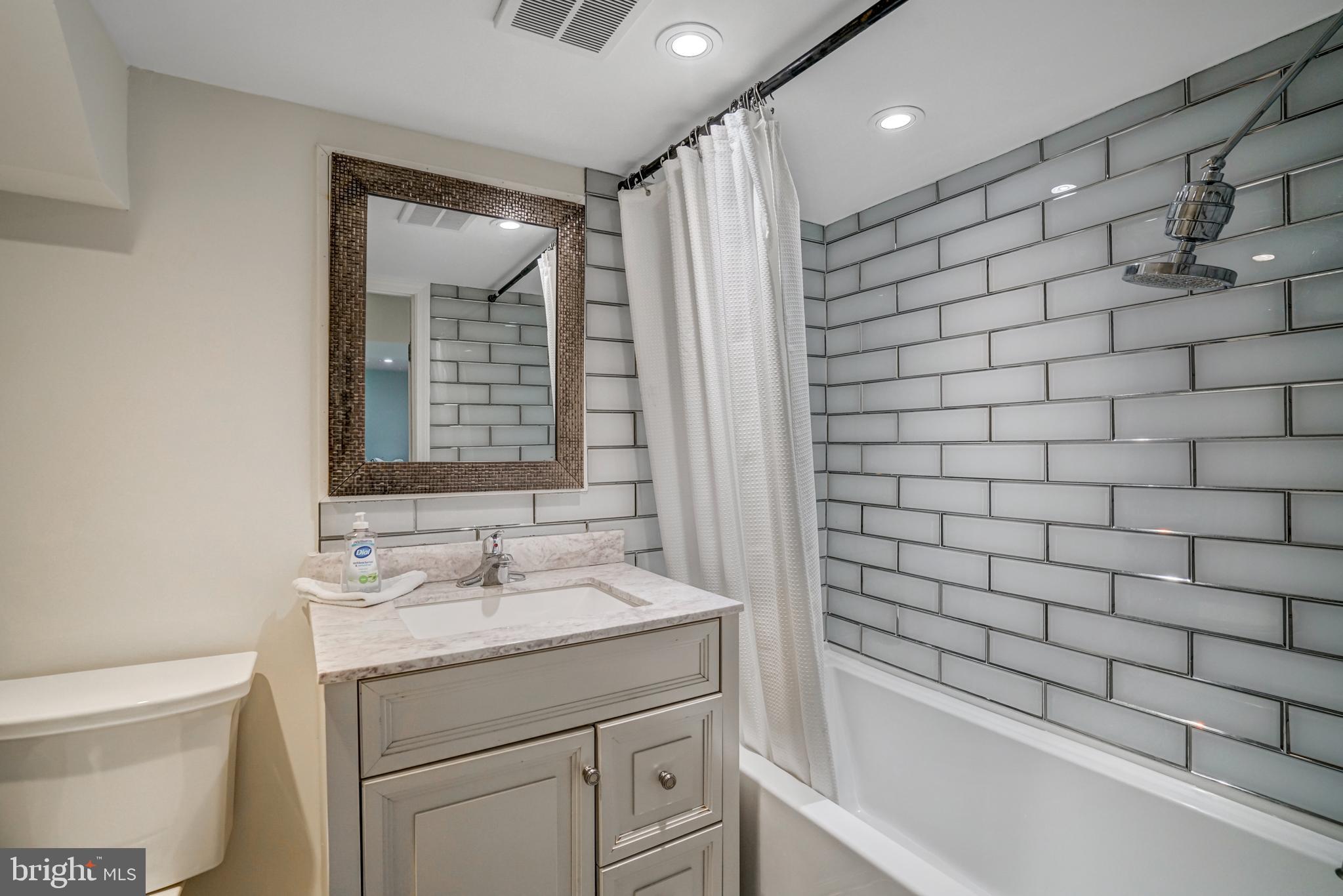 8941 Burke Lake Road Springfield, VA 22151 - Photo 28 of 34 a bathroom with a granite countertop sink a toilet and shower