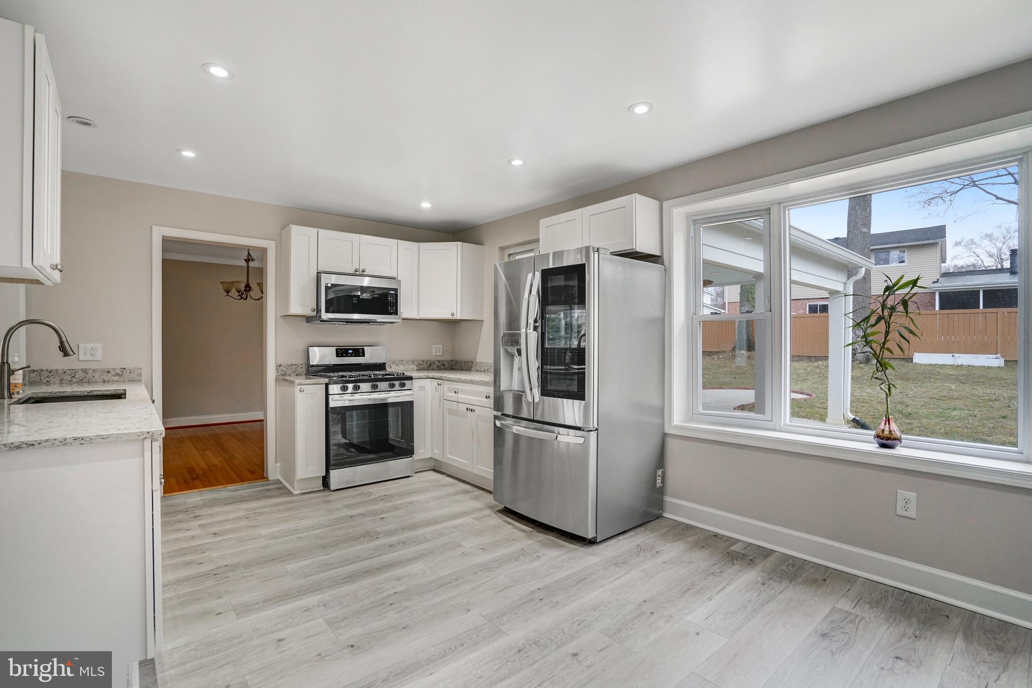 8941 Burke Lake Road Springfield, VA 22151 - Photo 5 of 34 a kitchen with granite countertop a refrigerator and a stove top oven