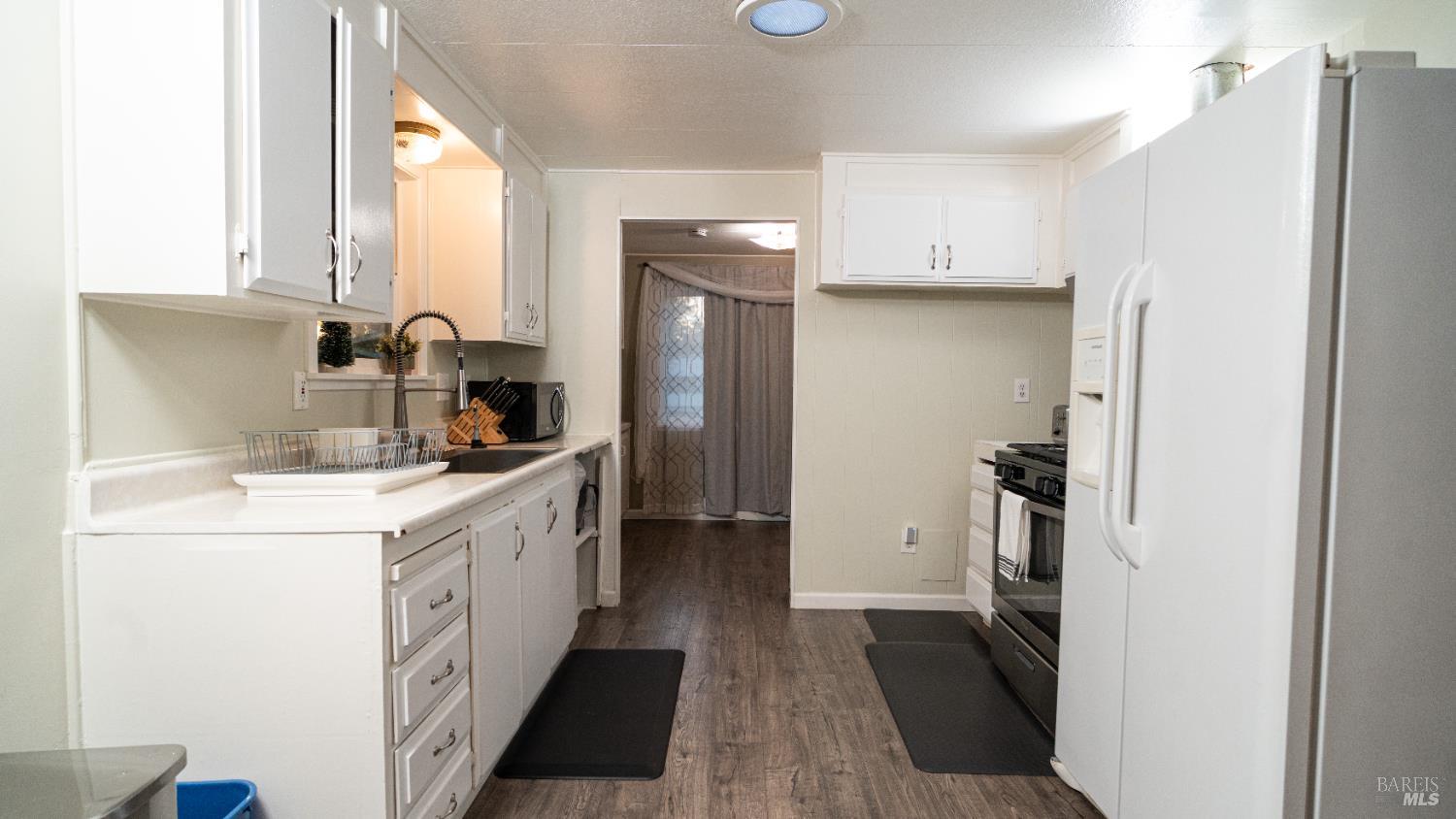 401 Frisbie Avenue Santa Rosa, CA 95407 - Photo 12 of 50 a kitchen with a sink a refrigerator a stove and cabinets