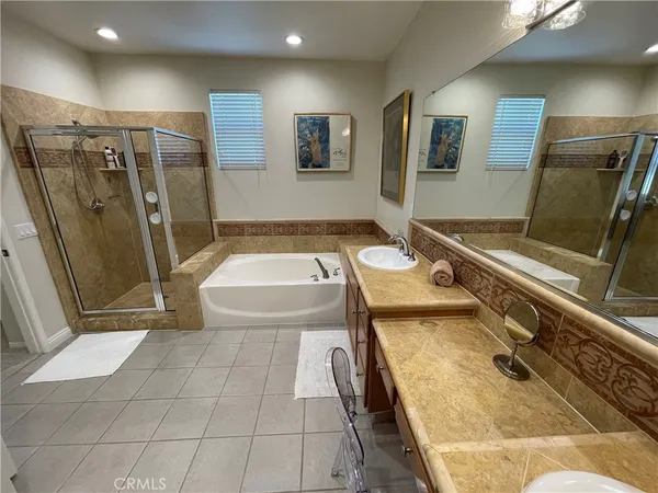 a bathroom with a tub a sink and glass door