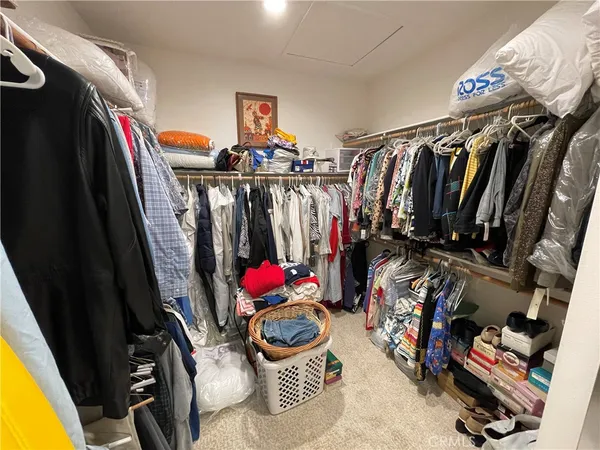 a view of walk in closet with clothes and shoes