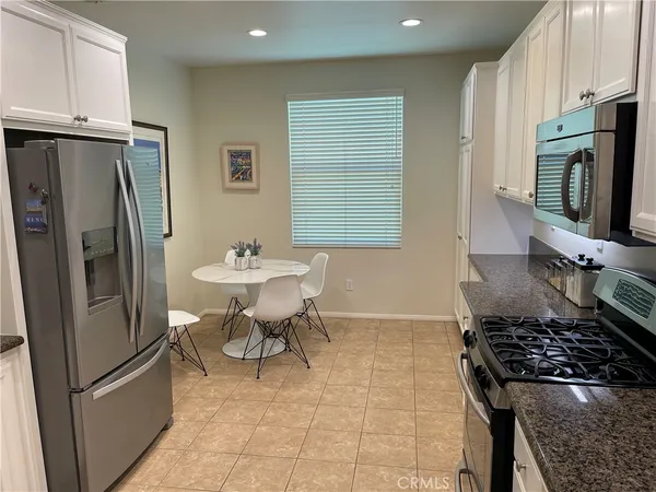 a kitchen with stainless steel appliances granite countertop a refrigerator stove and sink
