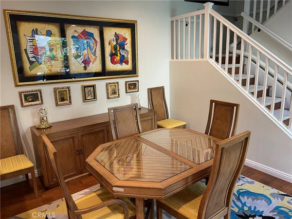 a view of a dining room with furniture a rug and wooden floor