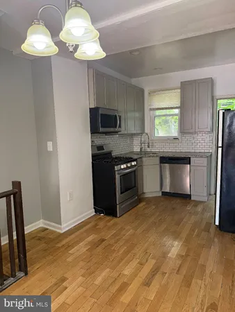 a view of a kitchen with a stove and a chandelier