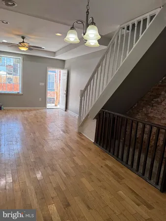 a view of a hallway with wooden floor and staircase