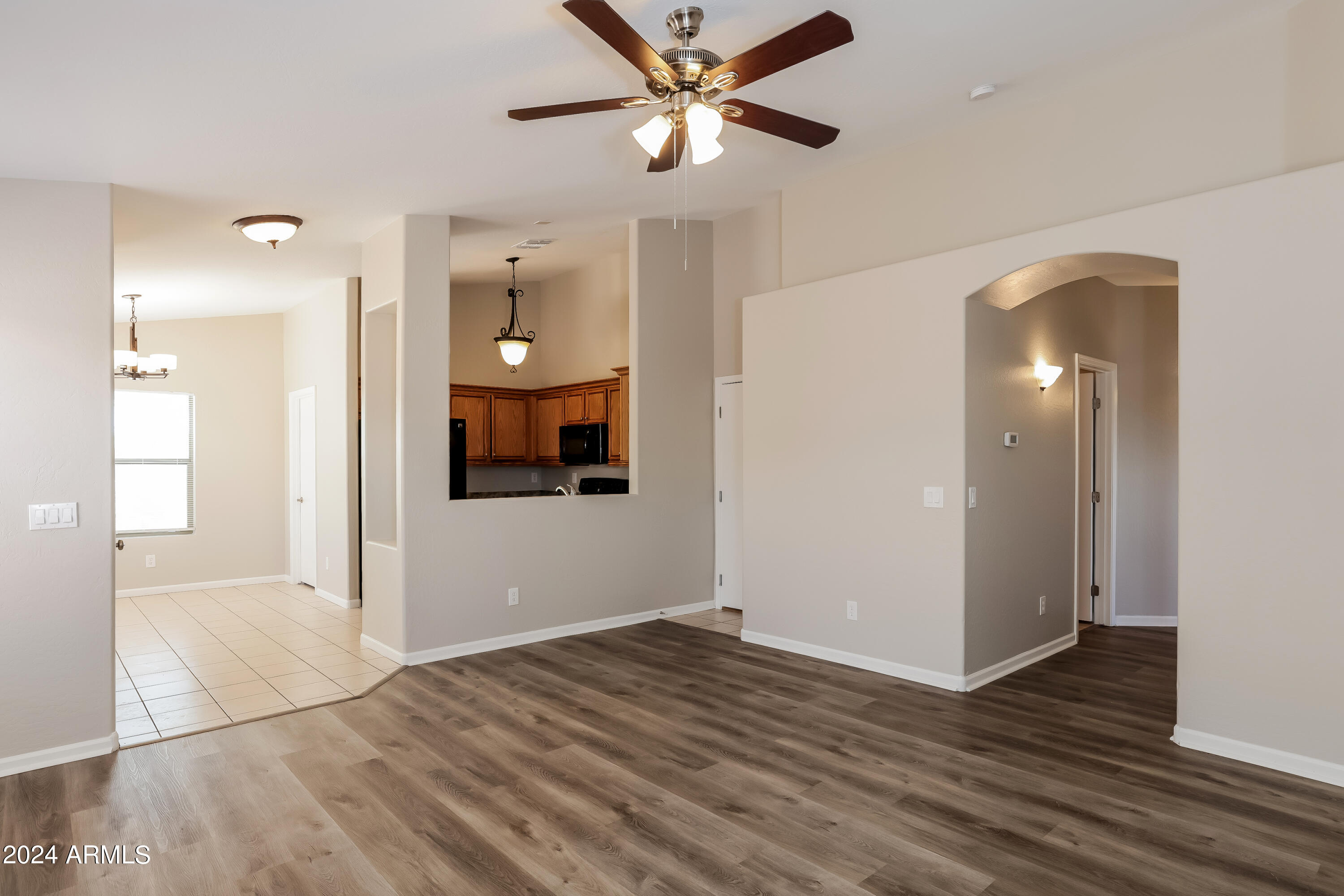 1815 East Hamel Way Phoenix, AZ 85022 - Photo 4 of 16 a view of a hallway with wooden floor and a kitchen