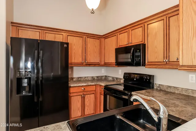 a kitchen with stainless steel appliances granite countertop a refrigerator stove and microwave