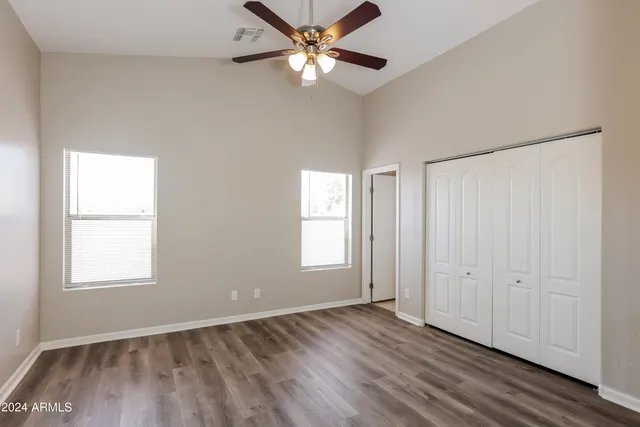 a view of an empty room with window and wooden floor