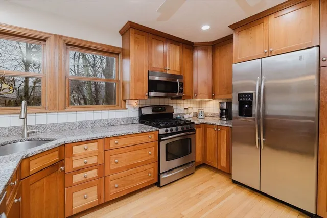 a kitchen with granite countertop a refrigerator and a stove top oven