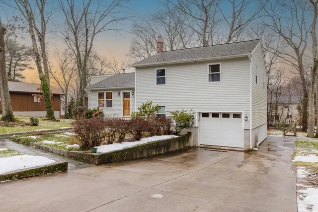 a view of a white house with a yard and large tree