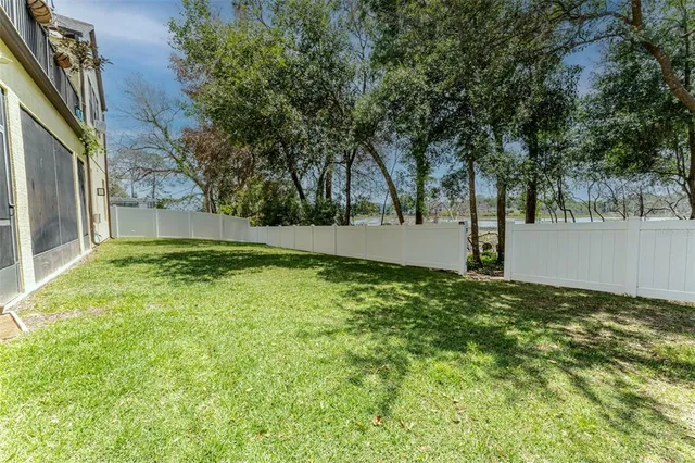a view of a brick house with a big yard and large trees
